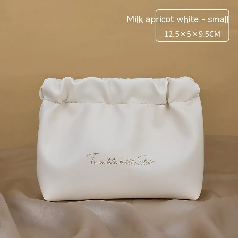 Large leather travel toiletry bag open to show dry and wet separation compartments.