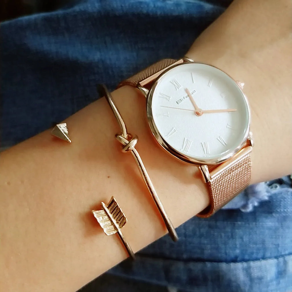 Gold women's vintage cuff bracelet with arrow knotted design on wrist