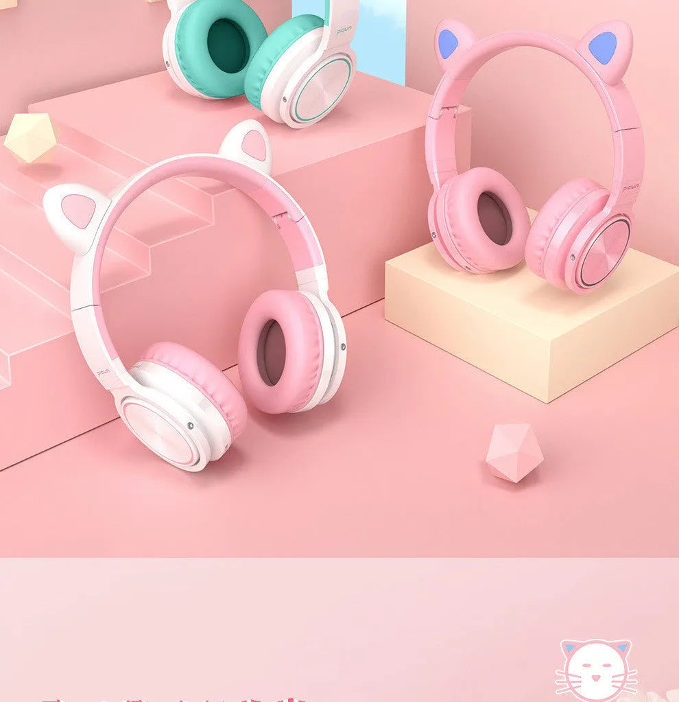 Pink and white Luminous Bluetooth wireless over-ear headset with microphone on a table.