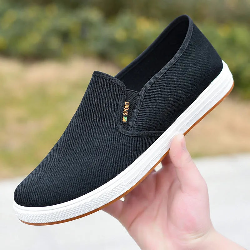 Men's black and blue slip-on canvas shoes with composite soles showing round toe design