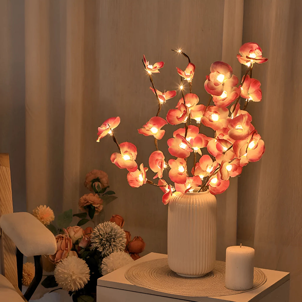 Pink LED Phalaenopsis branch decorative light on a table, 65cm long with fabric cover.