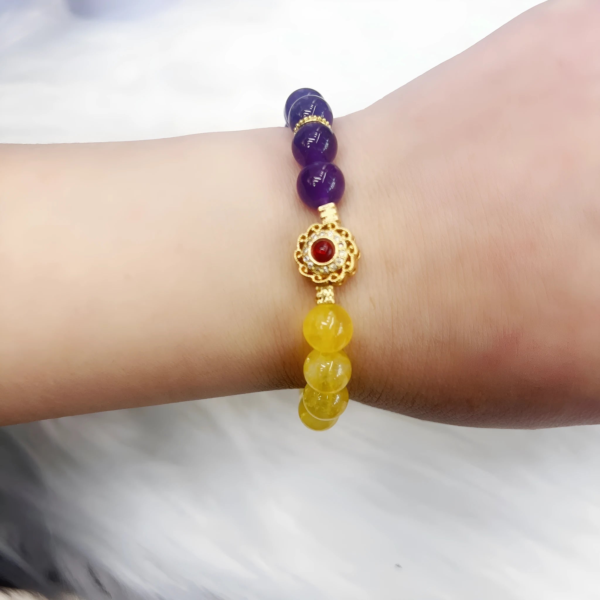 Handmade women's yellow and purple amethyst crystal bracelet on wrist