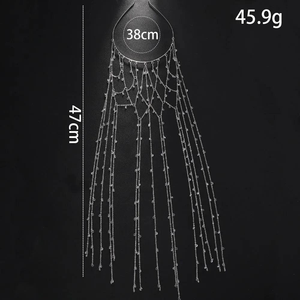 Gold rhinestone and mesh hairband with a long tassel, laid flat on a dark surface.