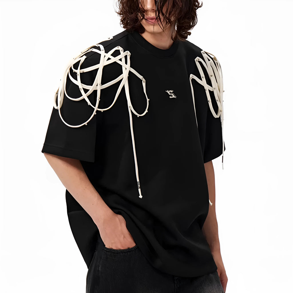Black loose-fit short-sleeve t-shirt with padded shoulders featuring a decorative rivet and ribbon detail.