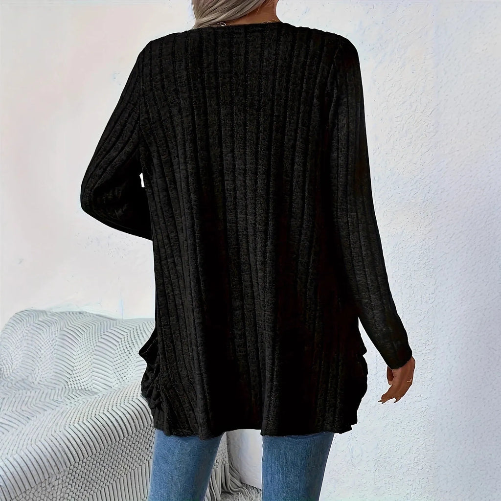 Plus size woman wearing a long sleeve grey cardigan with front pockets, loose fit.