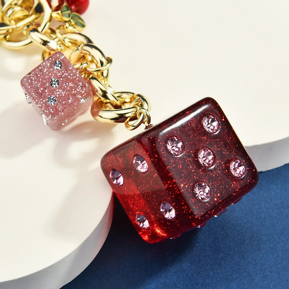Square metal keychain pendant with cherry two-tone dice design and electroplated finish