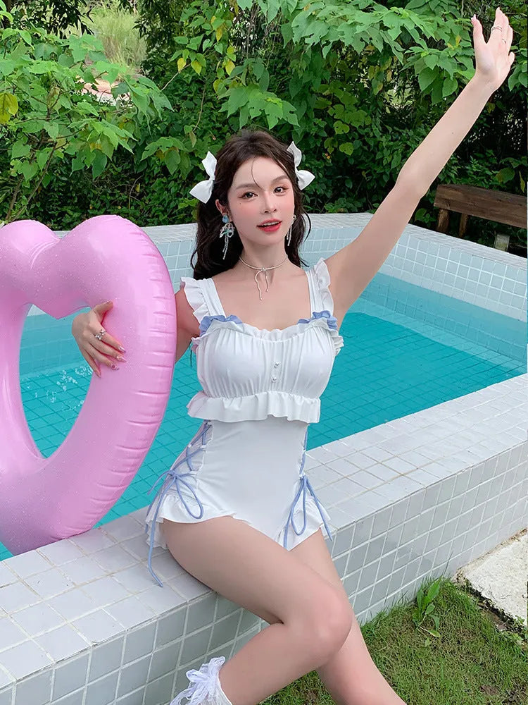 Milky White backless one-piece swimsuit on a model, showing sleeveless design and tight fit.