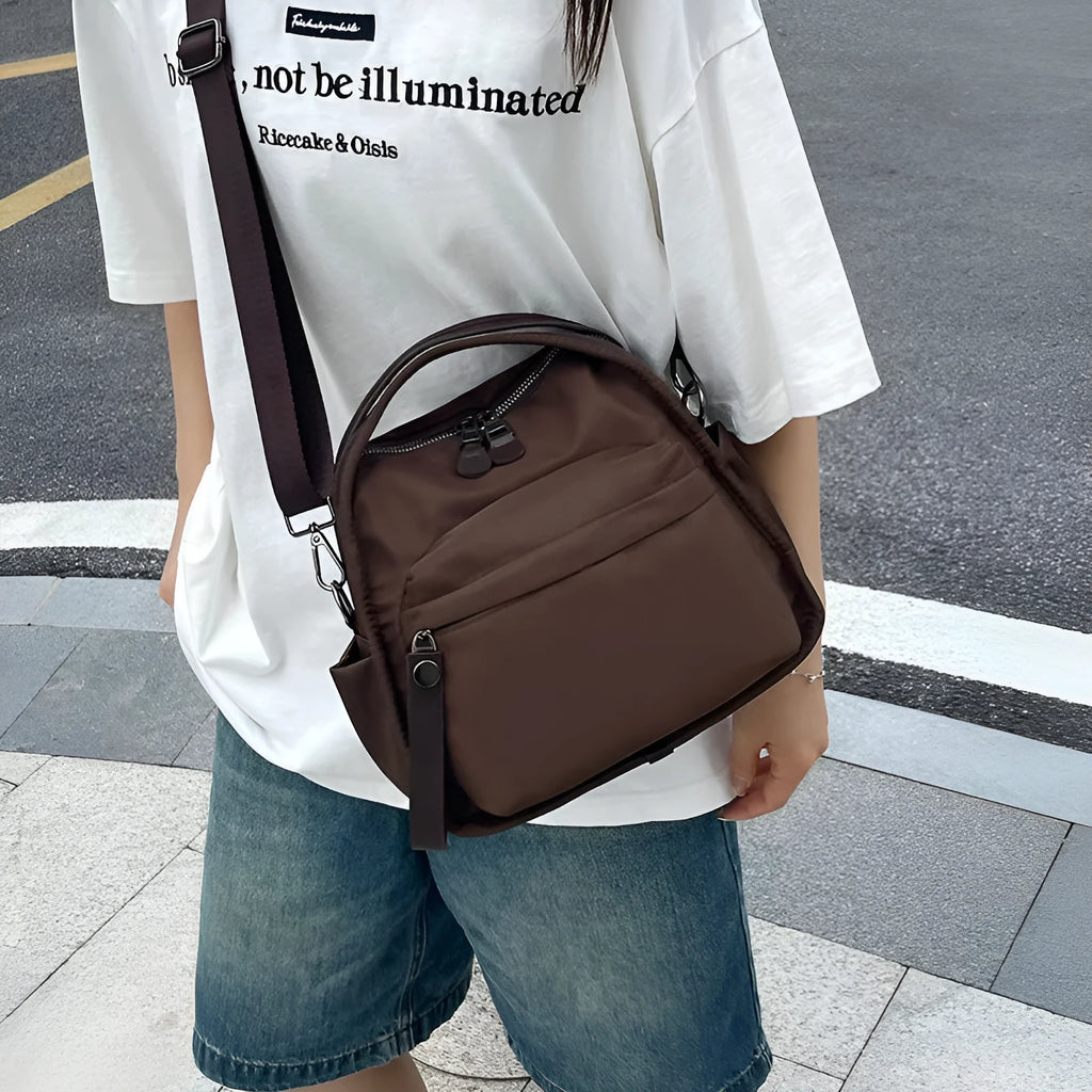 Vegan leather crossbody bag in black with double-stitched contrast thread, YKK zippers, and reinforced base