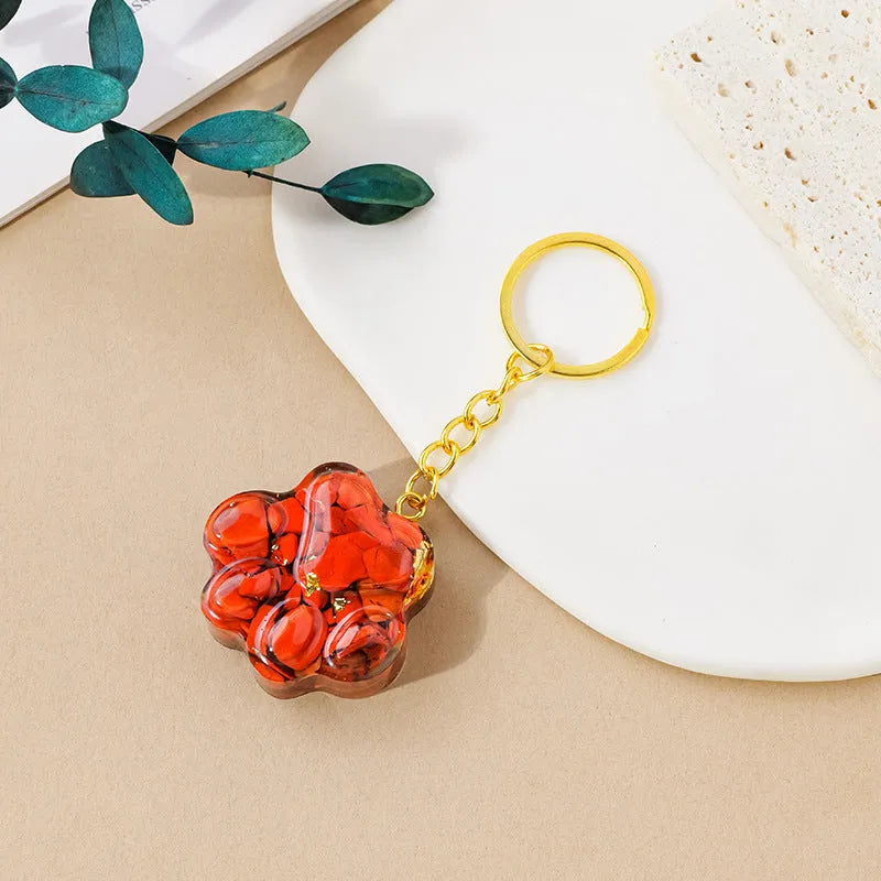 Small natural crystal cat's paw keychain pendant on a metal ring.