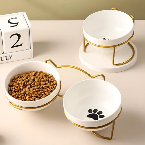 White ceramic cat bowl with cat paw print design on a black iron frame stand