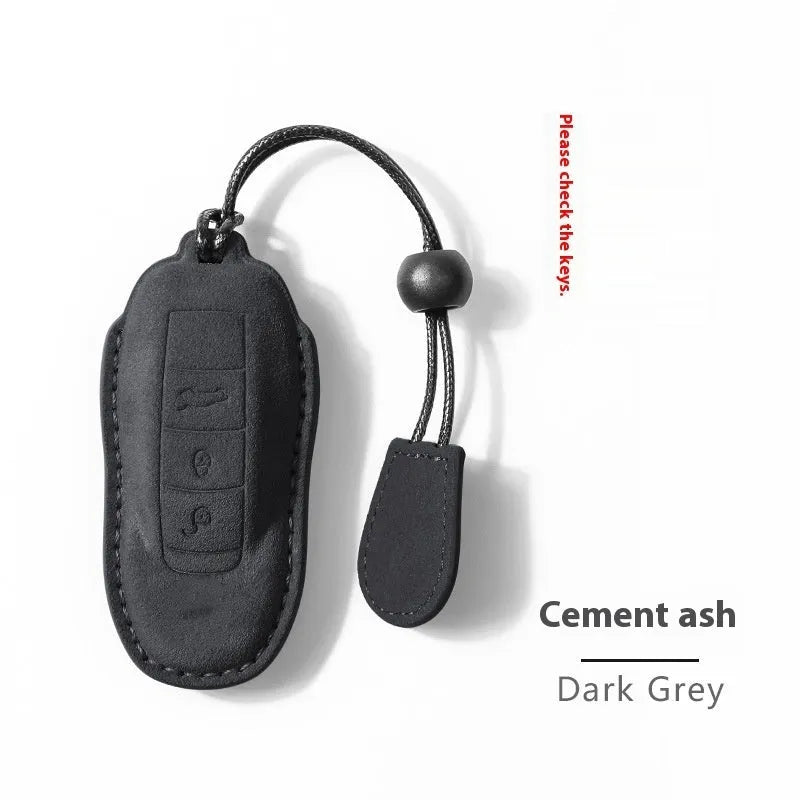 Suede car key cover in cement grey, dark green, light grey, and orange colour options.