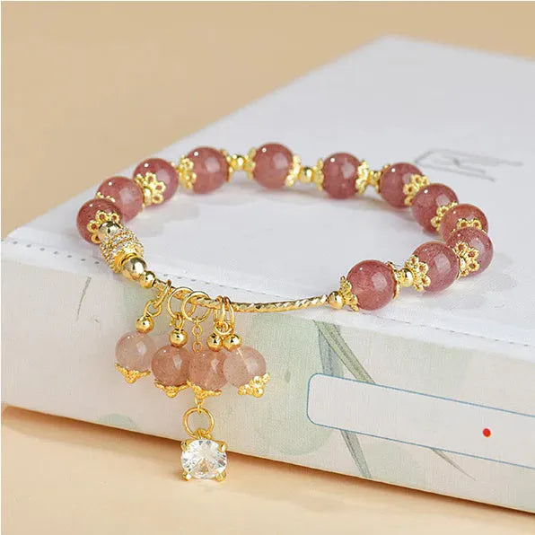 Women's pink crystal bracelet with heart-shaped design and pearl accents in strawberry quartz colour