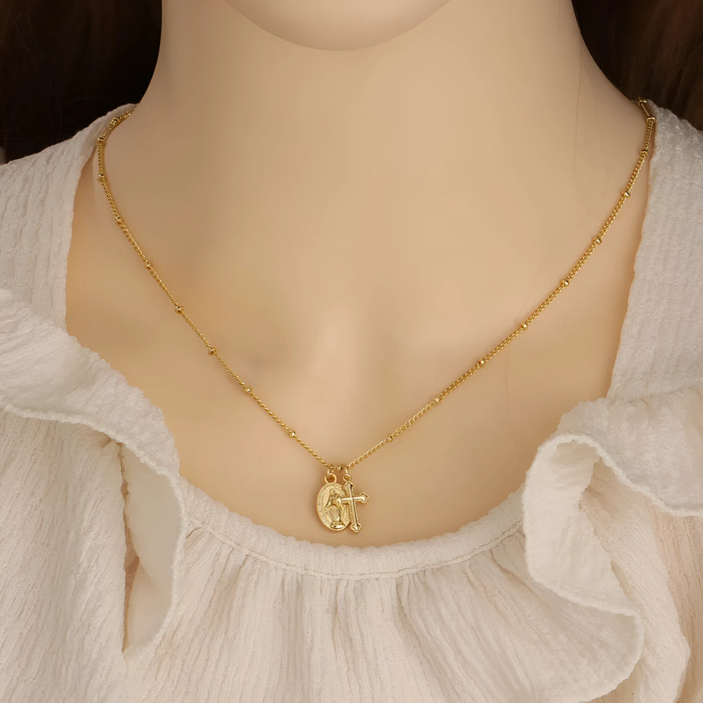 Geometric Cross Virgin Mary pendant necklace in gold on a simple chain.