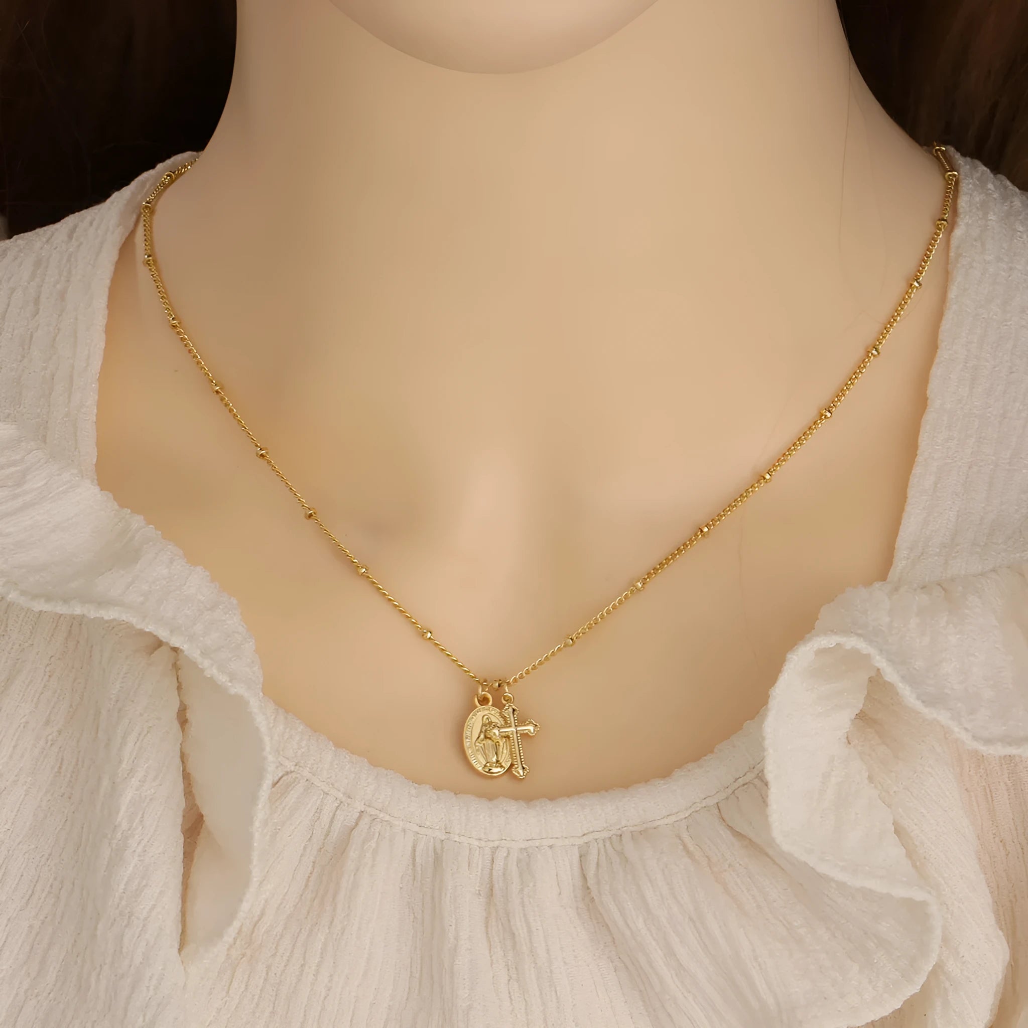 Geometric Cross Virgin Mary pendant necklace in gold on a simple chain.