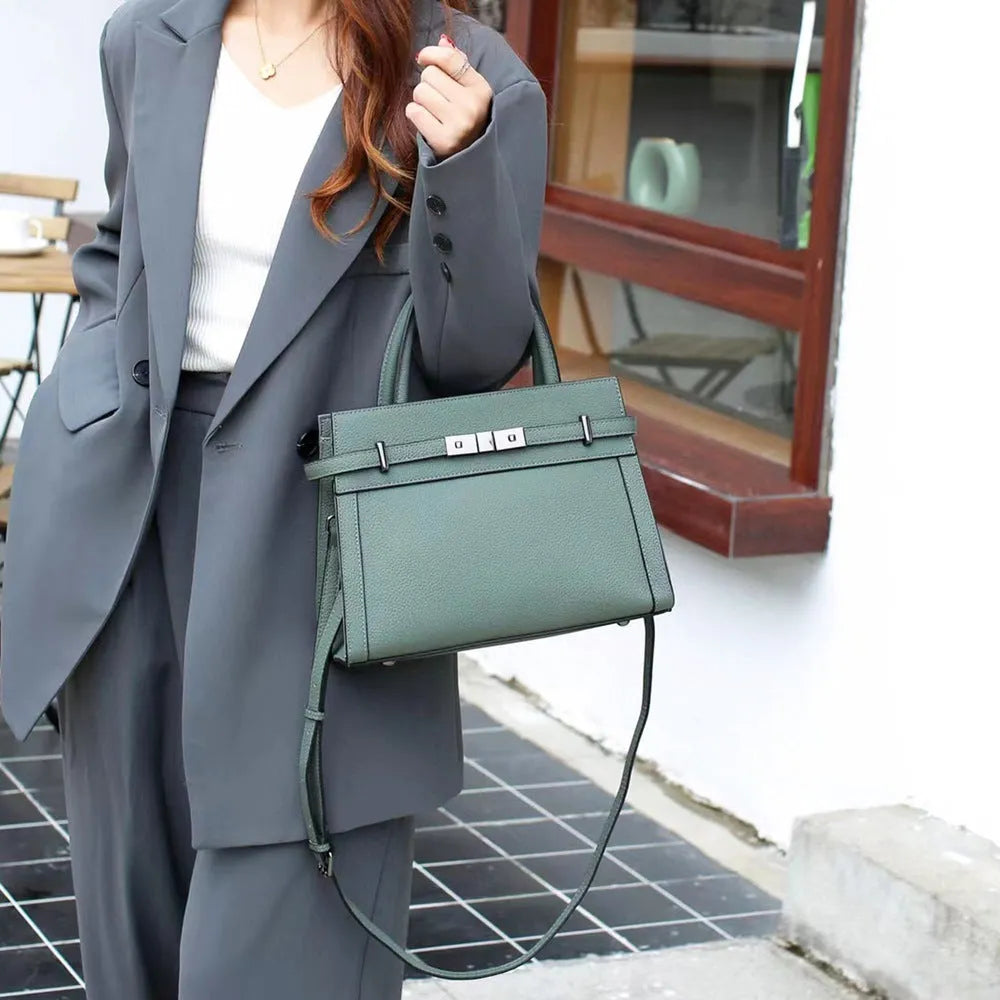 Genuine leather small square shoulder bag in almond green showing external pocket and stitching detail.