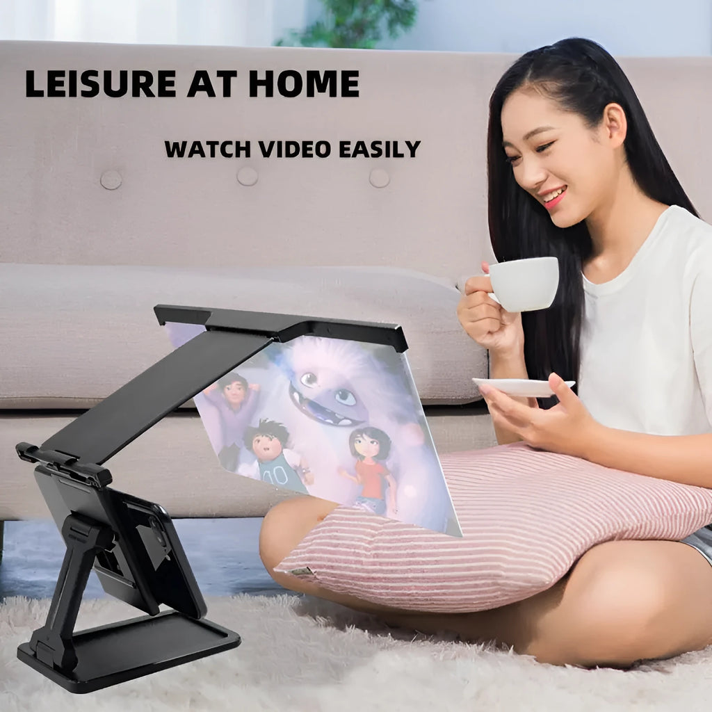 Black folding mobile phone screen magnifier with detachable phone holder on a desk.