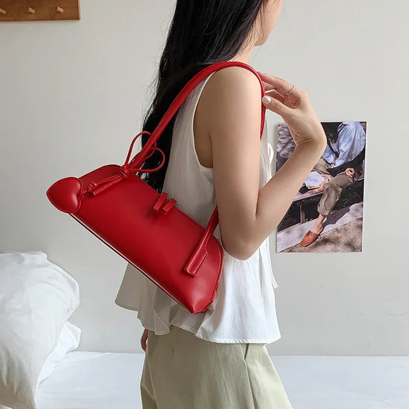 Crossbody shoulder bag in black PU with double straps, horizontal square shape, and visible sewing thread detail on front