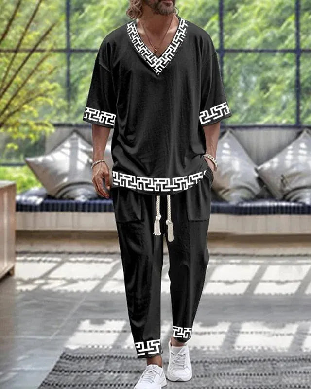 Thin polyester fibre co-ordinated suit with V-neck top, cropped sleeves, and matching trousers on a hanger.
