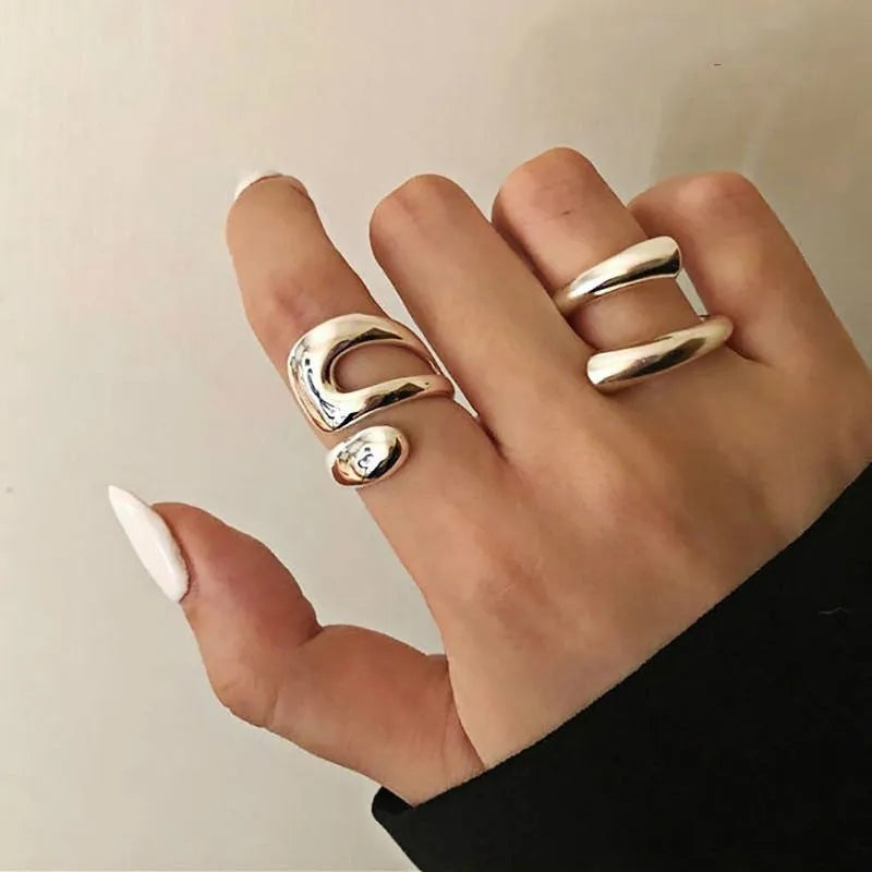 Silver tone adjustable geometric open ring with heart motif on a white background