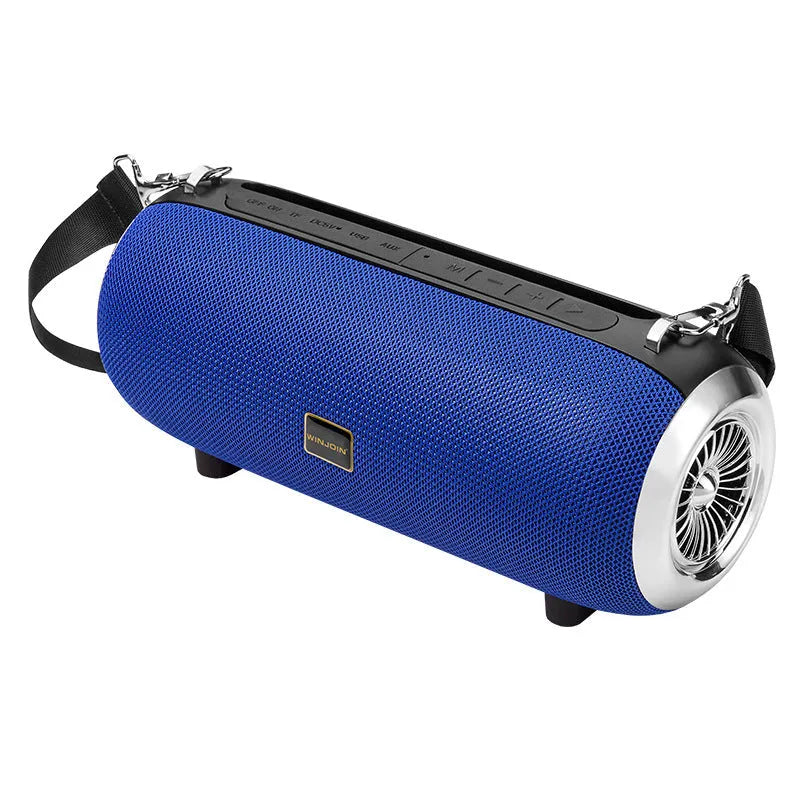Square fabric portable Bluetooth speaker with FM antenna, shoulder strap, and phone stand groove.