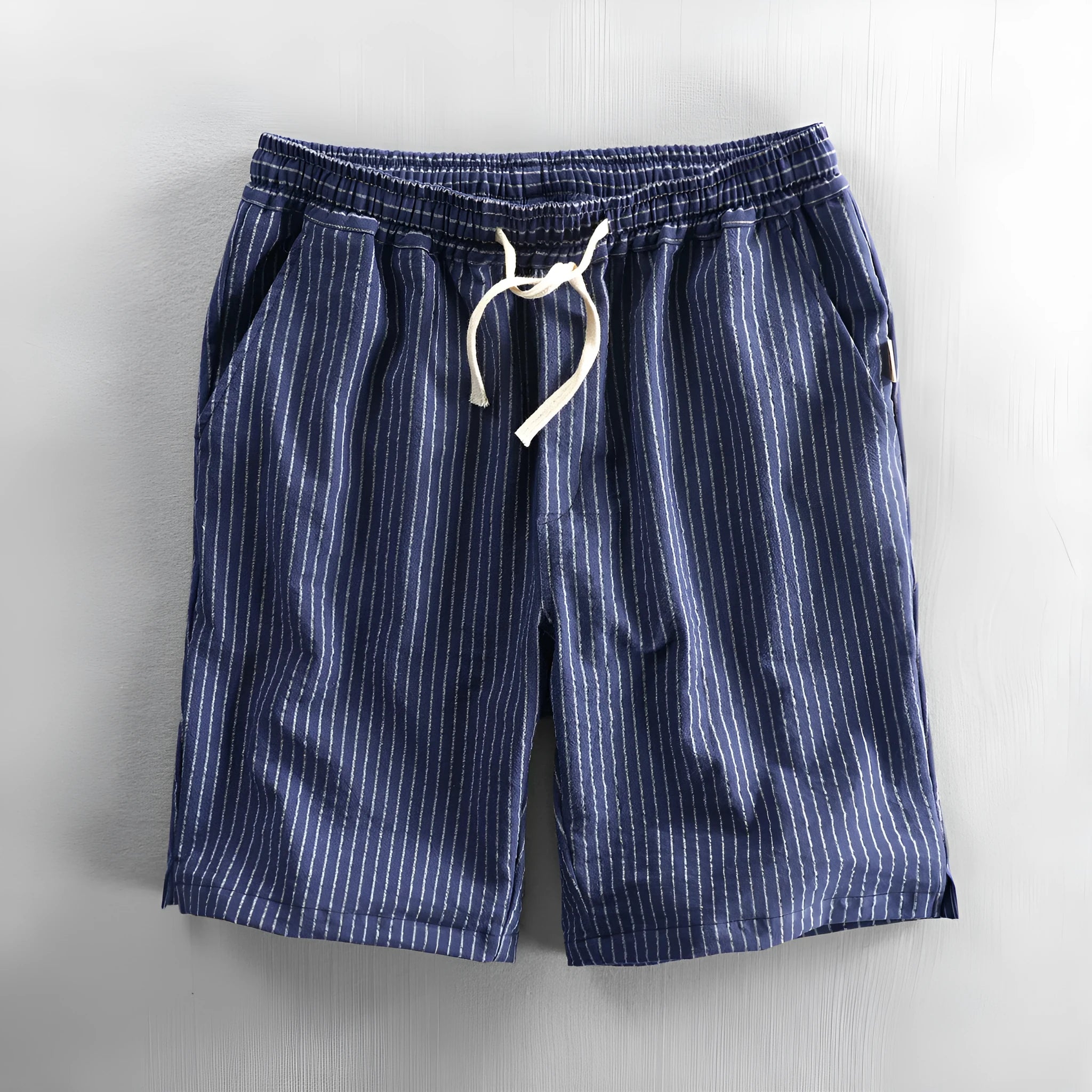 Man wearing black and white striped loose-fit casual cotton shorts with a mid waist.