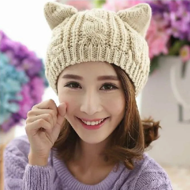 Hand made 3D knitted cat ear beanie in wool, shown in multiple colour options including red, black and beige.