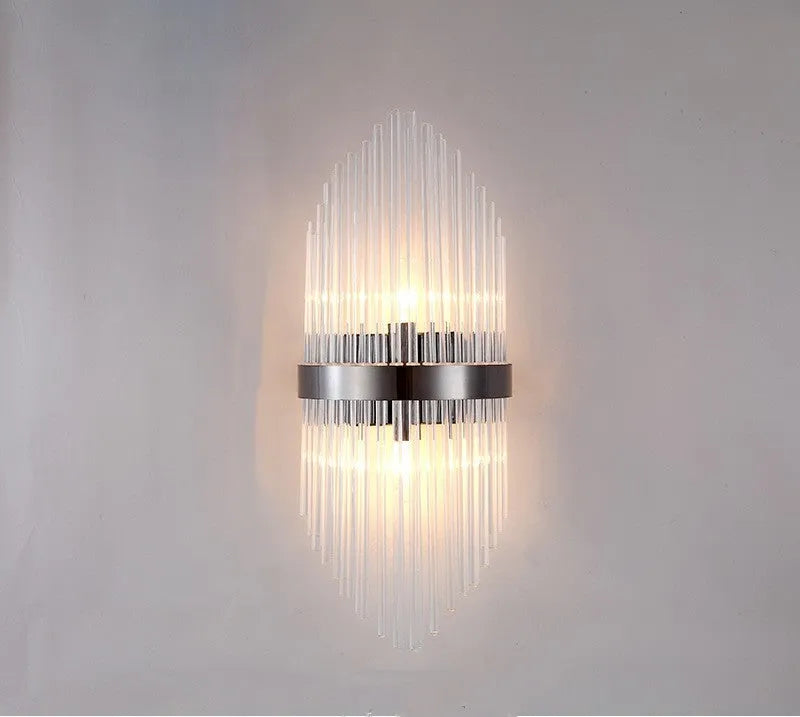 Modern crystal petal-shaped wall lamp in titanium gold finish mounted on a light-coloured wall.