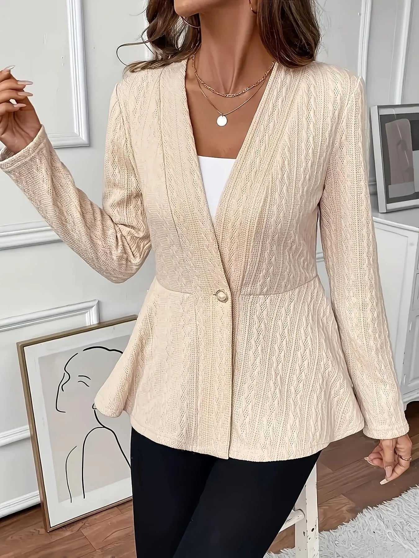 Women's apricot Jacquard knitted cardigan with a single button and long sleeves, laid flat.