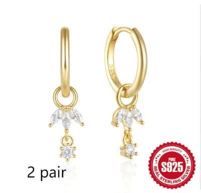 Close-up of geometric sunflower design sterling silver earrings with golden zircon stones.