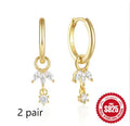 Close-up of geometric sunflower design sterling silver earrings with golden zircon stones.