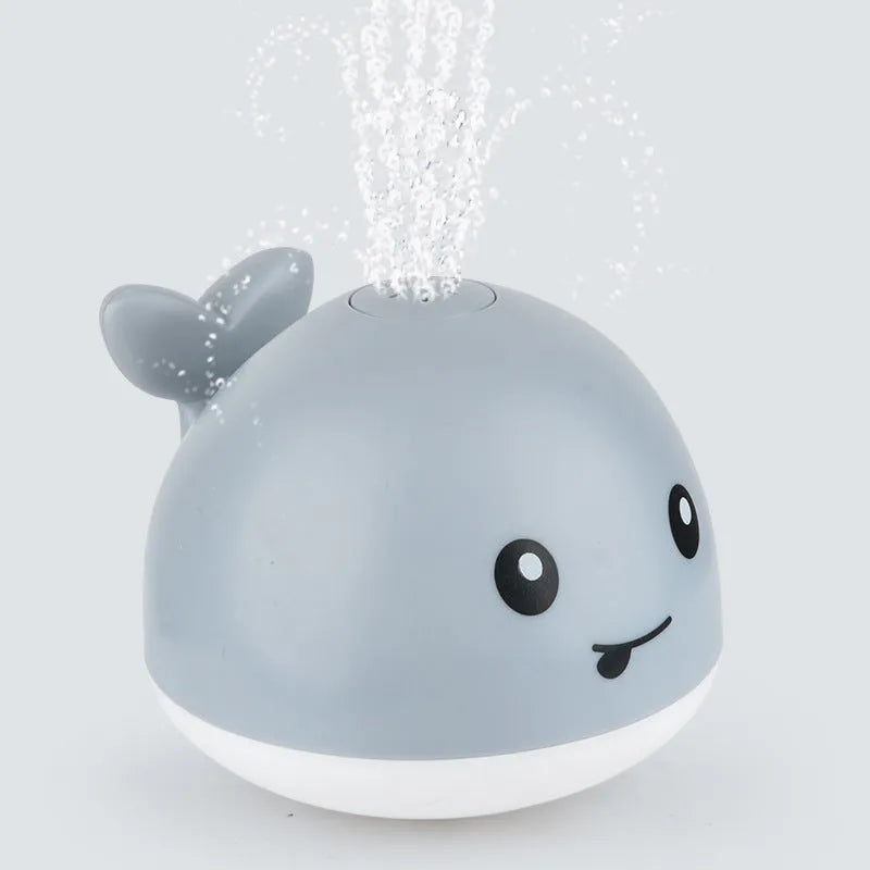 Automatic water-sensing whale bath toy with spray, lights, and music functions for baby bath time