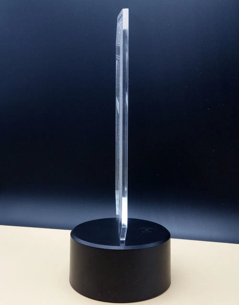 3D acrylic rose flower night light in black finish on a table, showing multicoloured LED illumination.