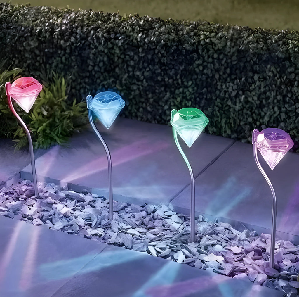 White solar-powered diamond-shaped garden spotlight with adjustable head on a stake.
