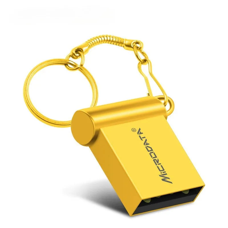 Silver car-shaped metal USB flash drive on a chain, shown next to a laptop.