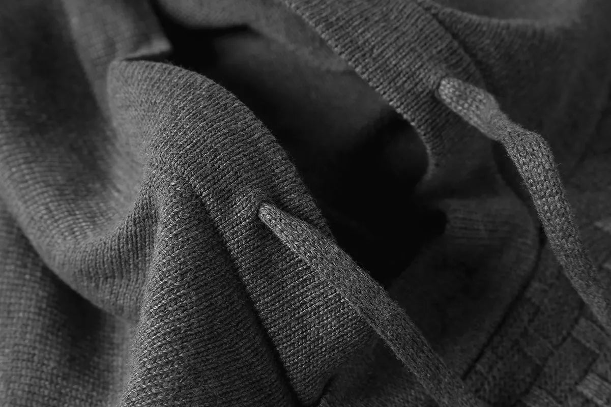 Men's black cotton-polyester blend hooded sweatshirt on a hanger, showcasing the front hood and kangaroo pocket.