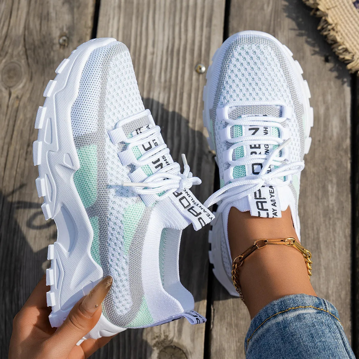 Women's lace-up Flyknit mesh sneakers in a grey colour combination with a round toe and flat rubber sole.