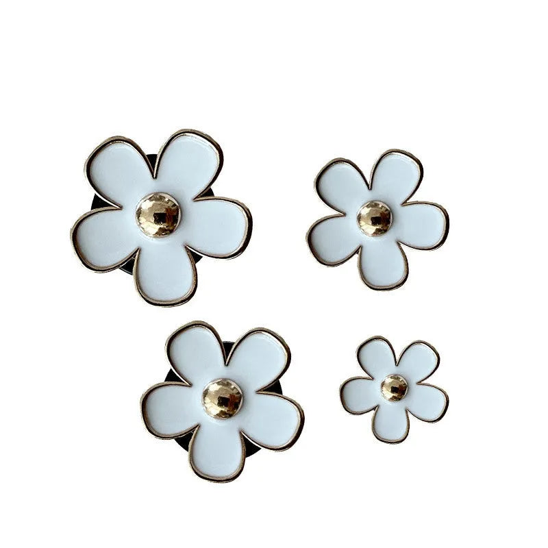 Set of four metal car air conditioning flower aromatherapy clips in assorted colours on white background