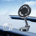 Black magnetic adhesive car phone holder with 360-degree adjustable bracket mounted on a dashboard.