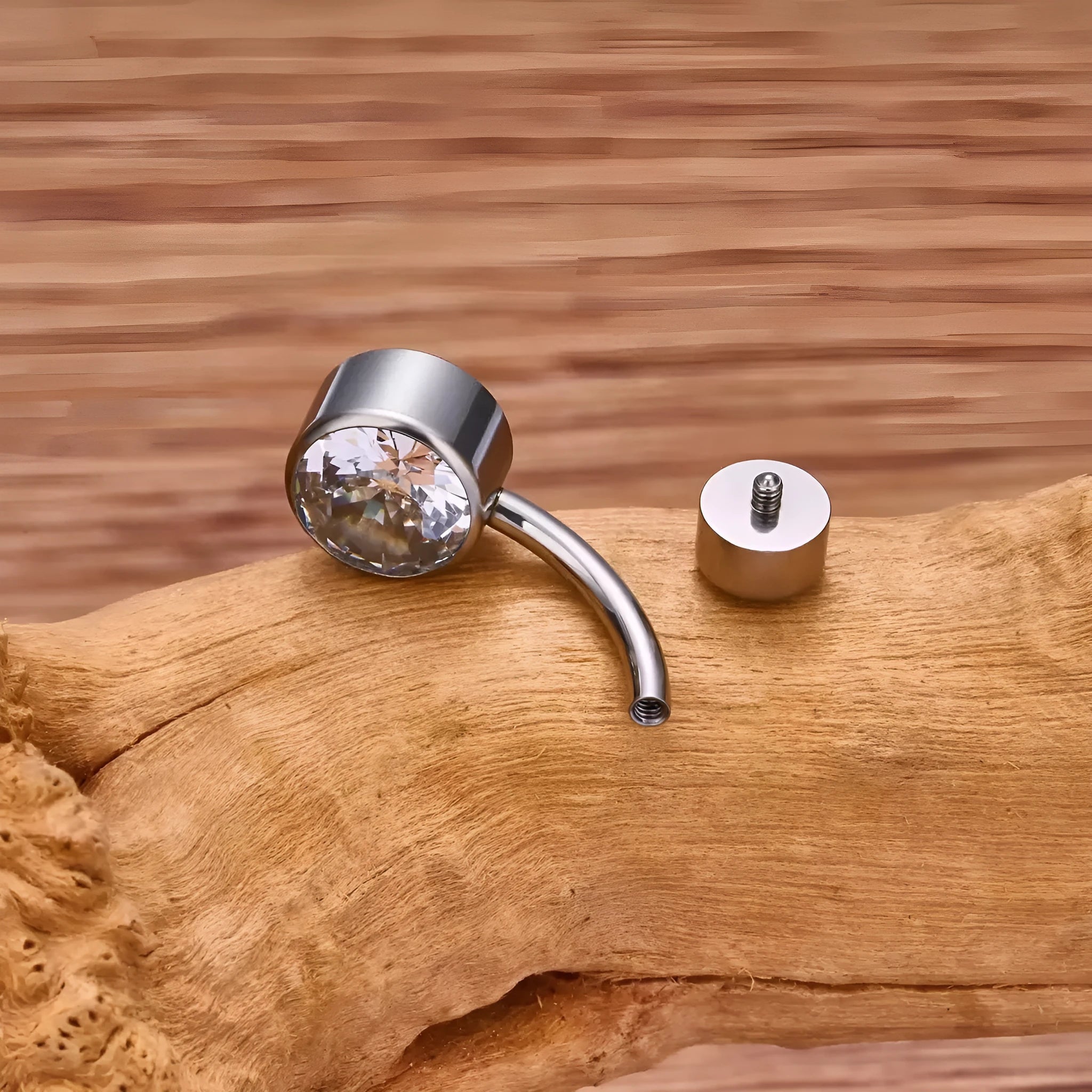 Double-headed zircon titanium alloy navel stud in various colours on a white background.