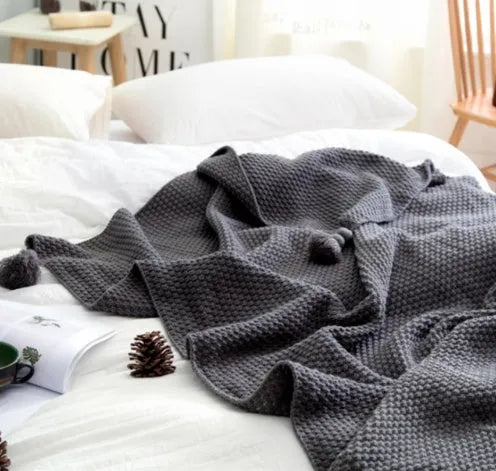 Nordic-style fringed knit acrylic blanket in a neutral colour, laid flat showing its 130x170cm size.