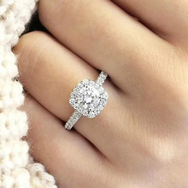 Geometric sculpted platinum alloy ring with diamond insert on white background