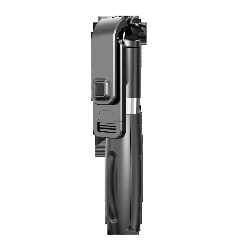 Extended black Bluetooth selfie stick with phone attached and separate wireless remote on a table