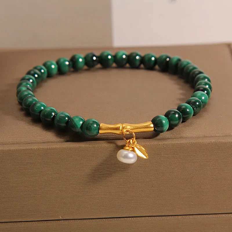 Women's white crystal bracelet with a high-rise lucky bamboo design on a wrist.