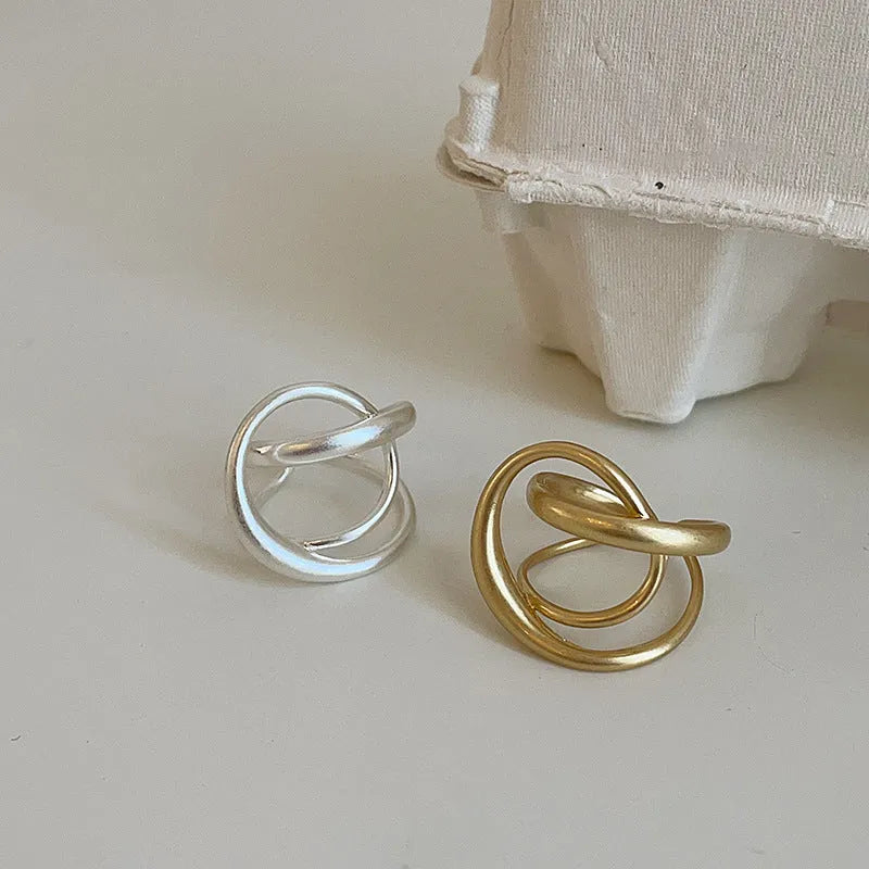 Geometric open ring with three-dimensional interlaced metal design in gold or silver colour