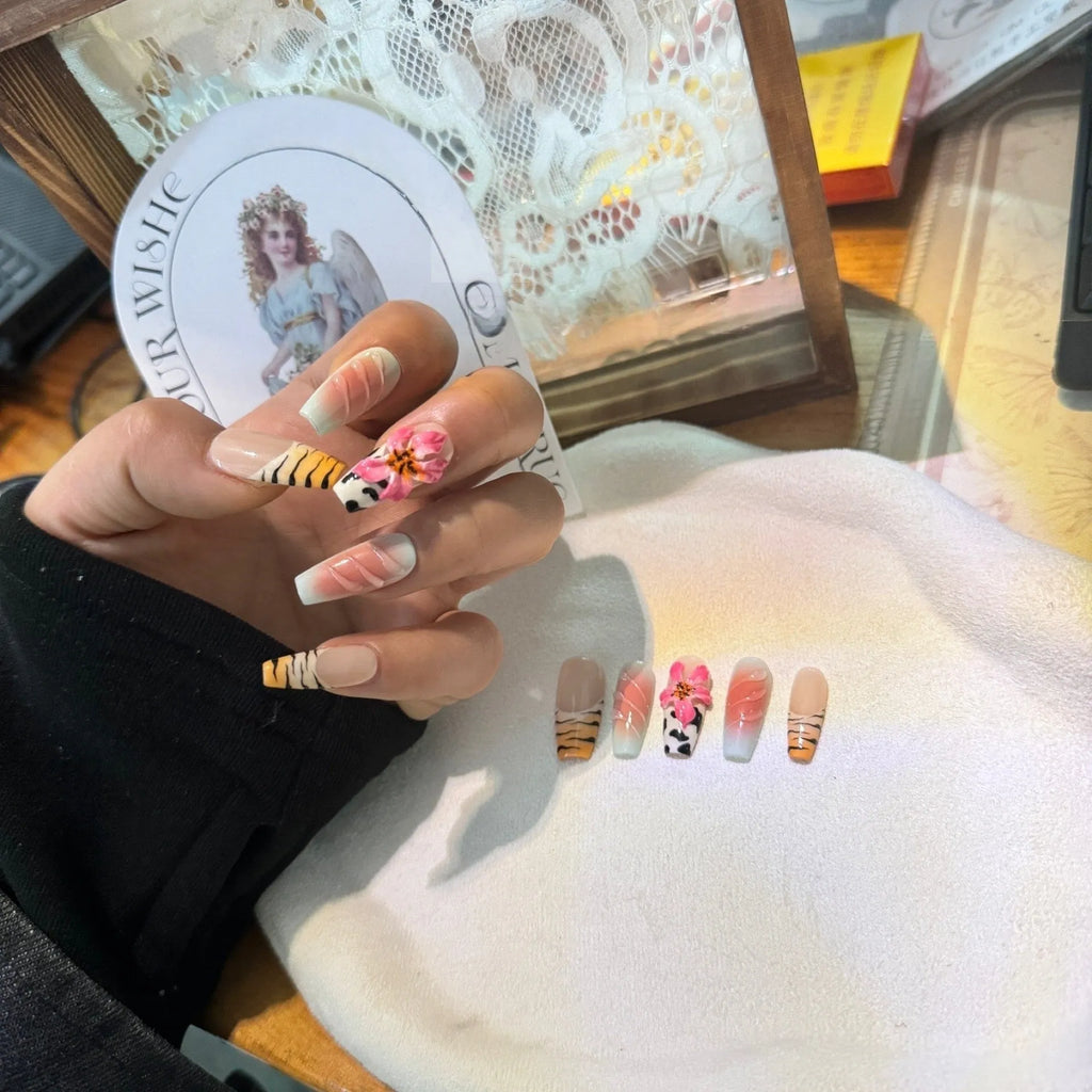 Set of false nails with zebra stripe, lily flower, and leopard print hand carving designs in long, wear-resistant style.