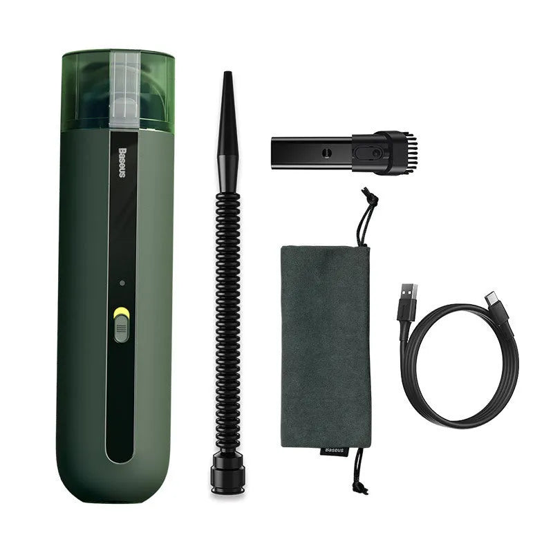 Black cordless handheld car vacuum cleaner with blowing hose attachment on a desktop.