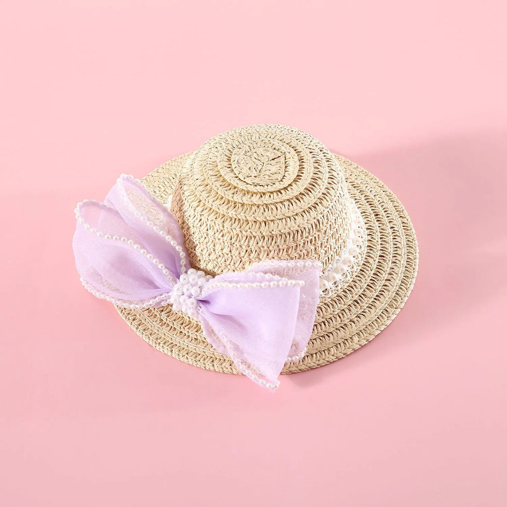 Woven straw hat for a cat with a large central pearl bow, available in blue, pink, purple, and white.