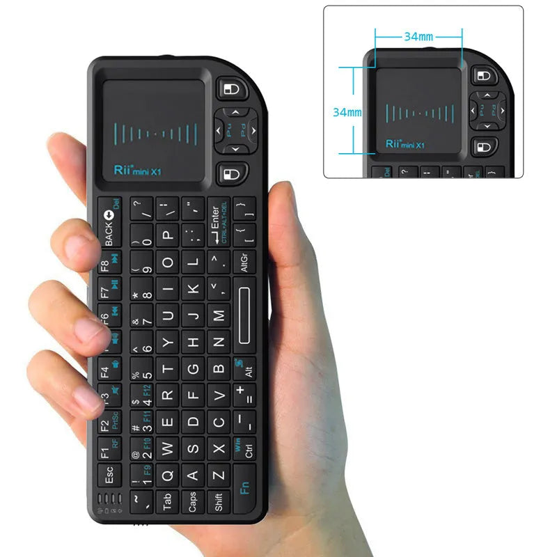 Black wireless mini keyboard with built-in trackpad and 2.4GHz receiver on a desk