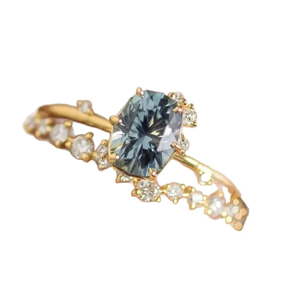 Gold plated women's ring with green zircon stone in flower-shaped design on finger