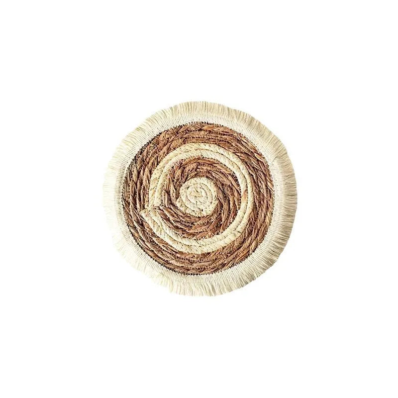Round Japanese straw placemat with corn rope tassel detailing on wooden table
